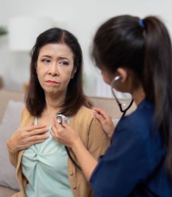 Lady having her heart checked by a nurse with a stethascope